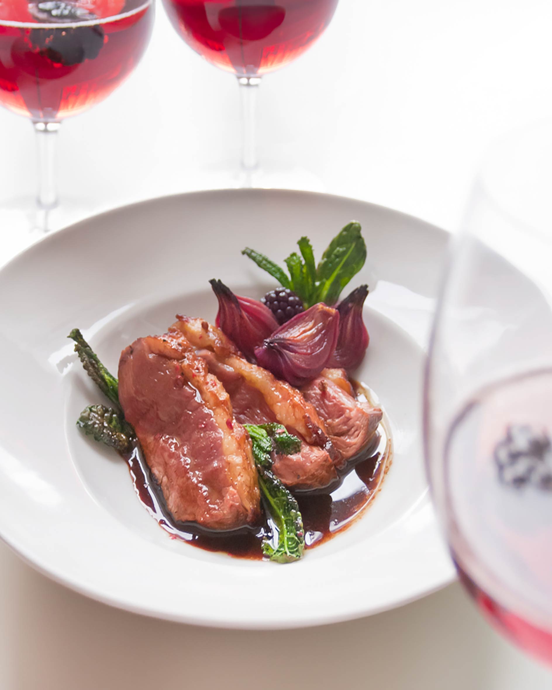 Petto d’anatra al vermouth rosso con cipolle caramellate, cavolo nero croccante e more